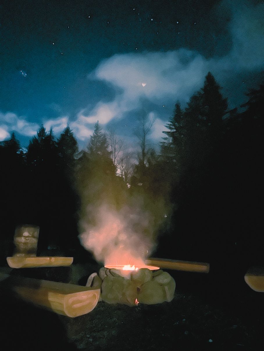 Sparks rising from the campfire under an evening sky