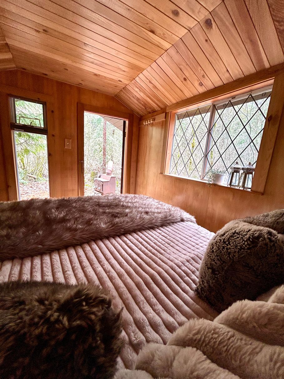 Soft bedding beside the Forest Cabin's leaded window