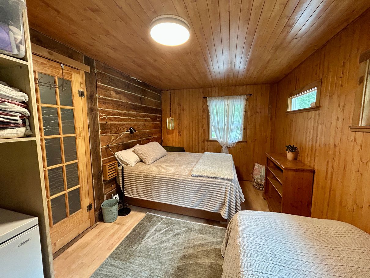 The main floor bedroom with a queen bed and a single bed