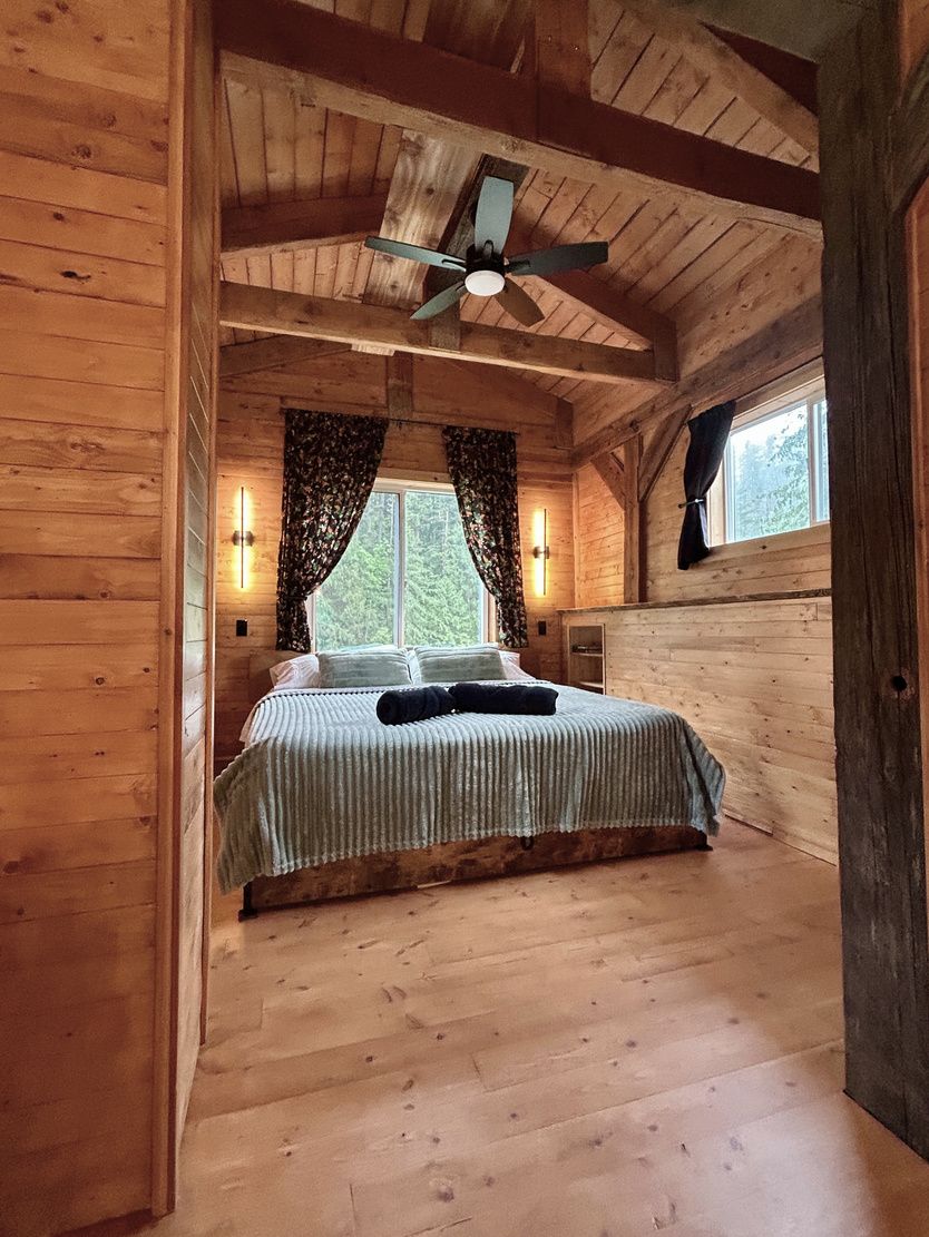 The loft bedroom with a king-size bed under vaulted wood ceilings
