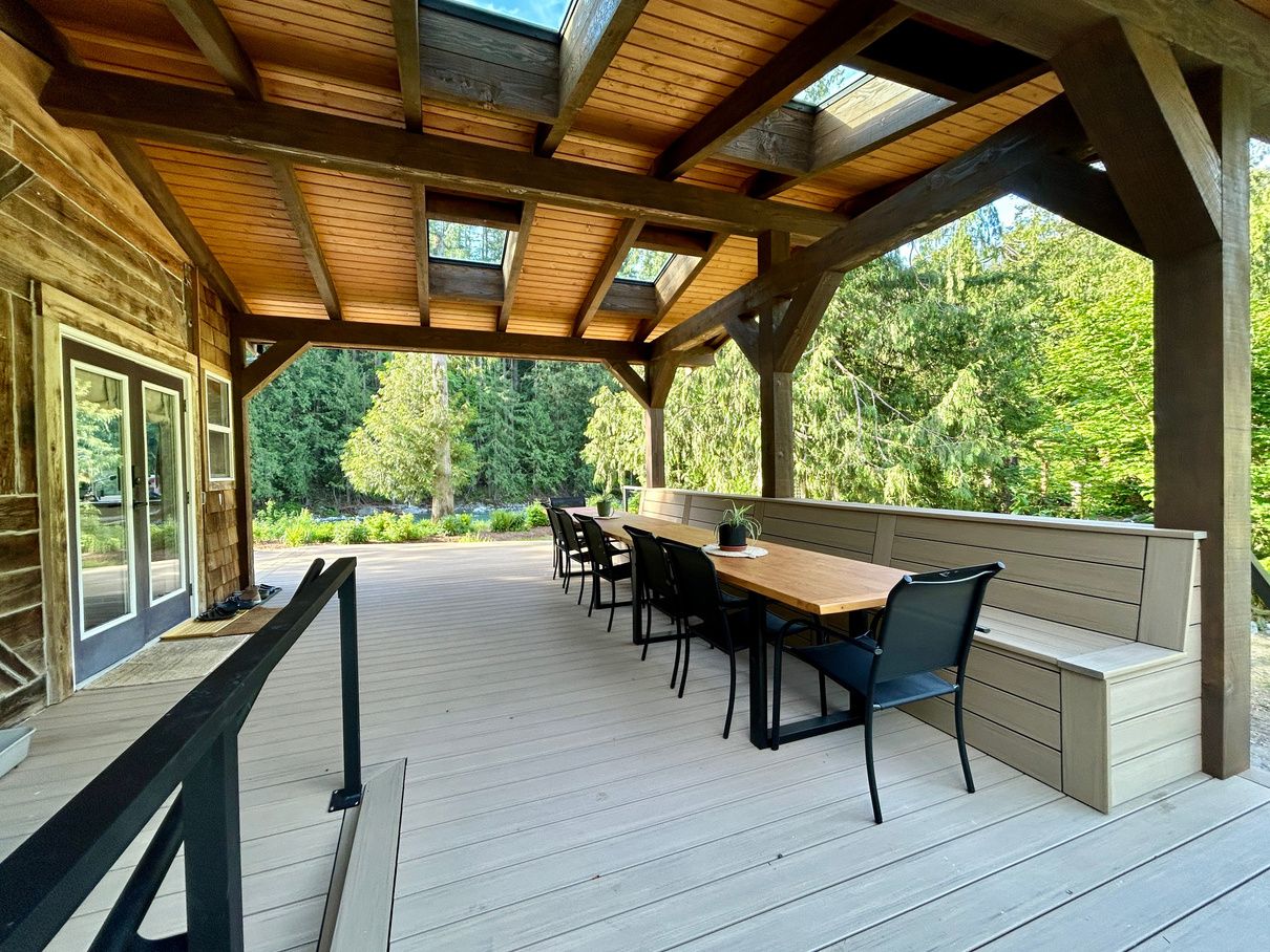 The covered porch with a long dining table beside the river